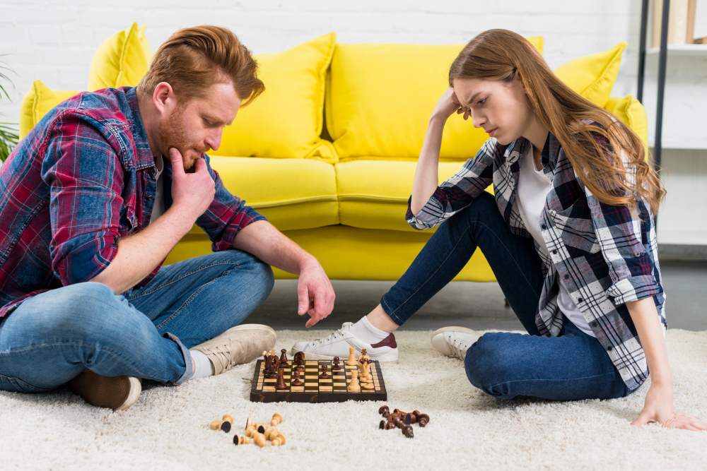 contemplated-young-couple-looking-chess-game-living-room